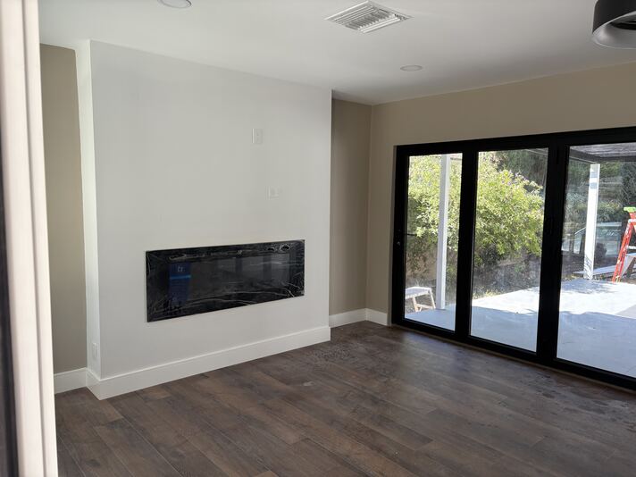 Living room with linear electric fireplace and black marble surround